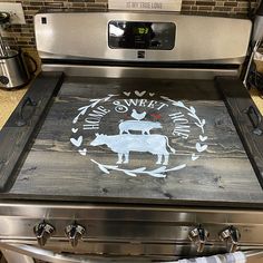 a stove top oven sitting inside of a kitchen next to an oven with a sign on it