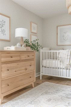 a baby's room with a crib, dresser and pictures on the wall