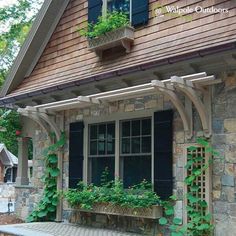 an old stone house with ivy growing on the windows