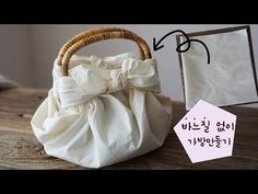 a white bag with a bow on it next to an envelope and some other items