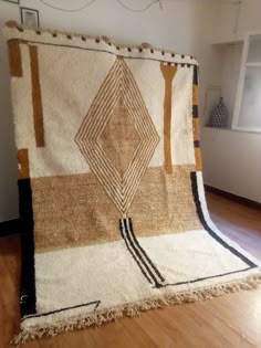 a large rug is on the floor in a room with wood floors and white walls