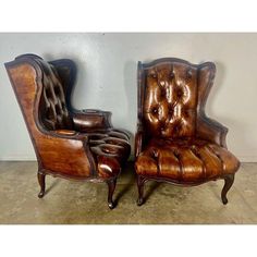 two brown leather chairs sitting next to each other