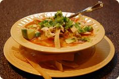 a white bowl filled with soup on top of a yellow plate