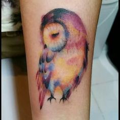 a colorful owl tattoo on the leg