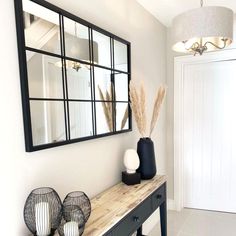 a table with two vases on top of it next to a mirror