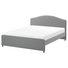 a bed with a gray headboard and white sheets on it's bottom half