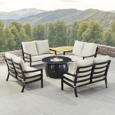 an outdoor patio furniture set with fire pit table and chairs on top of the patio