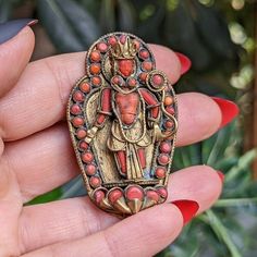 "A lovely handmade vintage / antique brooch from Nepal or Tibet, featuring a Red Tara goddess figure, The Mother of all Buddhas,  made of ornate brass with inlaid with small pieces of coral. The face is even carved! Overall in great condition with some natural age and patina. The stomach has a hairline fracture but is set securely in the piece. No markings. Simple \"C\" back closure." Traditional Red Handmade Brooch, Traditional Handmade Red Brooches, Hairline Fracture, Tara Goddess, Antique Brooches, Tibet, Nepal, Vintage Antiques, The Face