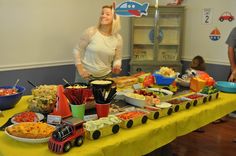 a woman standing in front of a table filled with food