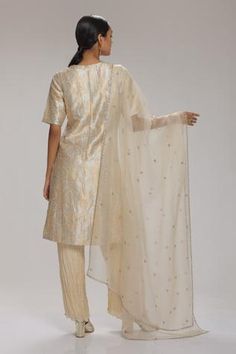 Cream kurta in brocade base with floral woven motifs. Paired with crushed habutai silk pant and dupatta. Component: 3 Pattern: Woven Type Of Work: Floral Neckline: Round Sleeve Type: Half Fabric: Kurta: Banarasi Brocade, Pant: Crushed Habutai Silk, Dupatta: Organza Color: Cream Other Details:  Embellished rhinestone sheer dupatta Closure: Back zipper Occasion: Sangeet - Aza Fashions Brocade Kurta, Sheer Dupatta, Banarasi Brocade, Silk Pant, Kurti Designs Latest, Gold Brocade, Cream Silk, Silk Dupatta