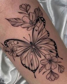 a black and white butterfly tattoo on the leg