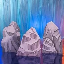 three white rocks sitting on top of a blue floor next to a curtained wall