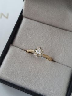 an engagement ring in a box on top of a table