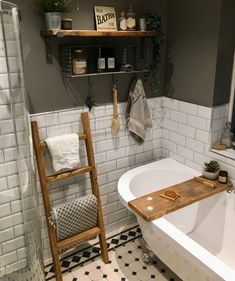 a white bath tub sitting next to a wooden ladder