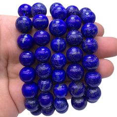 a hand holding several blue marbles in it's palm