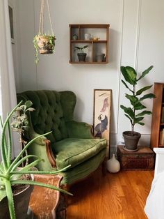 a living room with a green chair and potted plants on the wall next to it