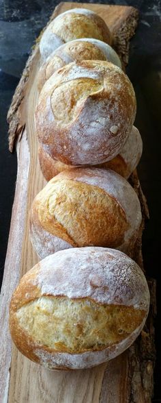 several loaves of bread sitting on top of a wooden board