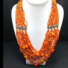 *Description: This vintage 1970's Czech glass seed bead necklace has 16 strands of orange glass beads which move into larger glass beads and connect to 12 strands. It is the perfect Boho necklace from the 1970's. It has two brass toned caps with lobster claw closure. It is in great vintage condition. The length of this necklace is 23 inches for the shortest strand. This would be a great addition to your vintage jewelry collection or make a great vintage gift! *Approximate Measurements: Length - Vintage Orange Necklace With Colorful Beads, Orange Faceted Beads In Bohemian Style, Bohemian Orange Faceted Beads, Orange Bohemian Faceted Beads, Orange Multi-strand Beaded Necklace With Polished Beads, Vintage Orange Beaded Chain Necklace, Orange Multi-strand Polished Beaded Necklaces, Orange Multi-strand Polished Beaded Necklace, Vintage Orange Beaded Necklace