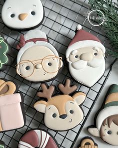 decorated christmas cookies sitting on top of a cooling rack