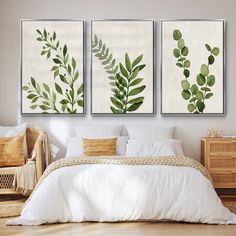 three green leaves are hanging on the wall above a bed in a room with hardwood floors