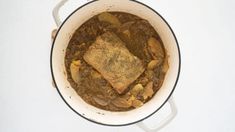 a pot filled with stew sitting on top of a white counter