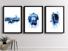 three framed art prints depicting blue and white sports jerseys on a wall above a stool