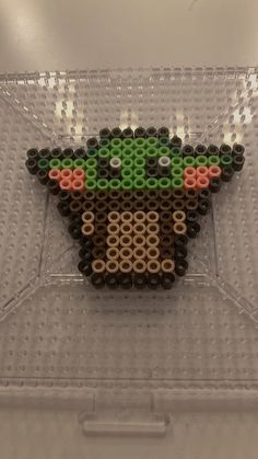 a star wars yoda bead art piece on display in a clear plastic container