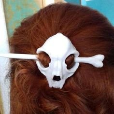 a woman with red hair has a fake skull on her head