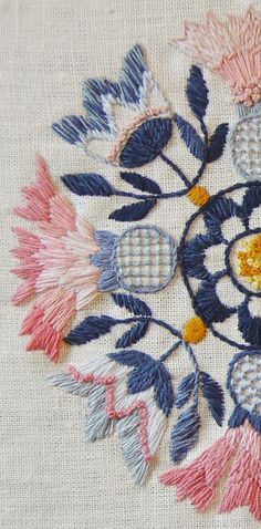 a close up of a piece of cloth with flowers and leaves embroidered on the side