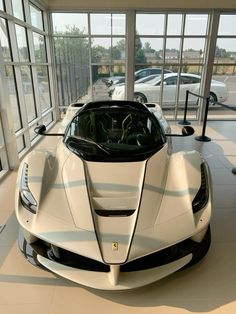 a white sports car is parked in a showroom