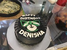 a birthday cake sitting on top of a table next to other foods and condiments