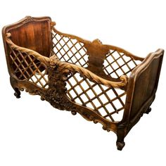 an old wooden baby crib with carvings on the sides