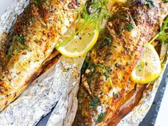 grilled fish with lemons and herbs on foil