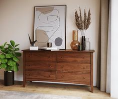 a wooden dresser sitting next to a plant in a living room