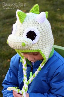 a young child wearing a crocheted hat with an animal face