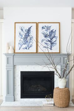 a fireplace with two framed pictures above it