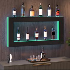 an illuminated shelf filled with liquor bottles on top of a counter