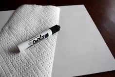 a pen sitting on top of a piece of white paper next to a napkin with the word dad written on it