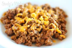 a white plate topped with ground beef and cheese