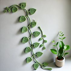 a potted plant sitting on top of a white table next to a wall decoration