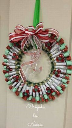 a wreath made out of wine bottles with a green ribbon hanging from the front door