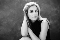 a black and white photo of a woman sitting on the floor with her legs crossed