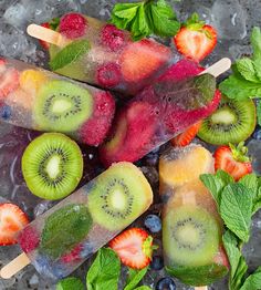 fresh fruit popsicles on ice with mint leaves and strawberries