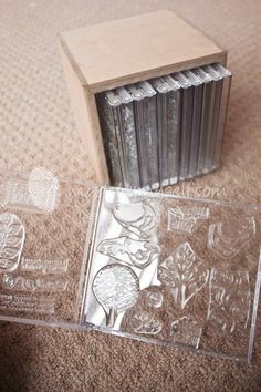 some clear stamps sitting on top of a carpet next to a wooden box and stamp pad