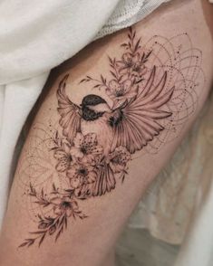 a bird and flowers tattoo on the thigh