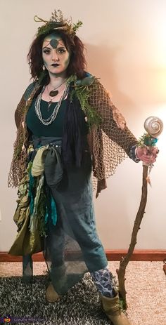 a woman dressed in costume holding a wand