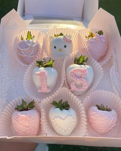 chocolate covered strawberries are arranged in the shape of hearts and letters with a hello kitty figurine