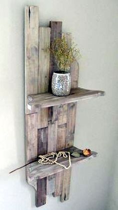 a shelf made out of pallet wood with a vase and chain hanging on it