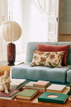 a blue couch sitting next to a table filled with books