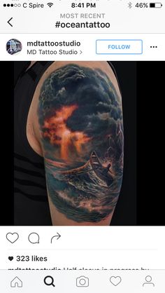 a man's arm with a boat in the ocean on it and clouds above